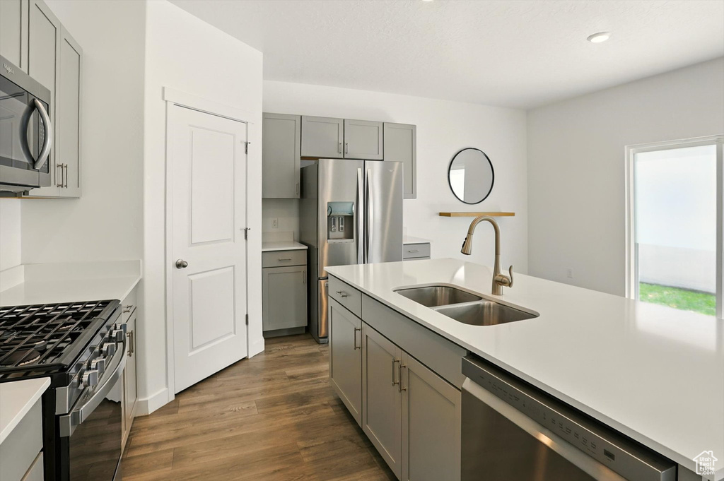Kitchen with gray cabinets, appliances with stainless steel finishes, light countertops, dark wood finished floors, and recessed lighting