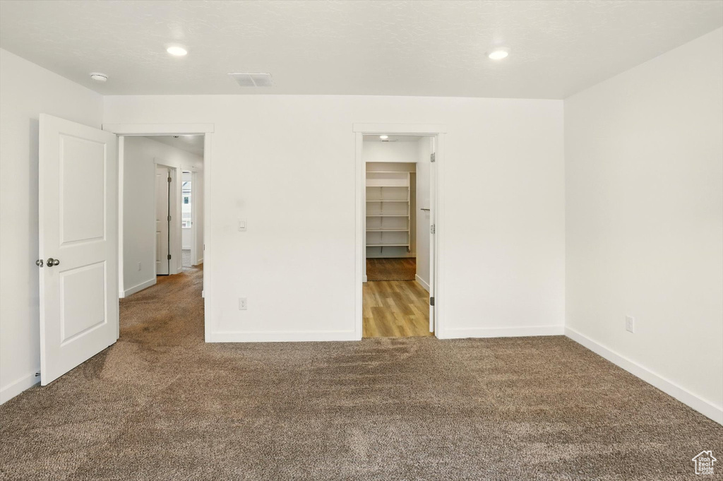 Unfurnished bedroom featuring carpet floors, recessed lighting, and a spacious closet