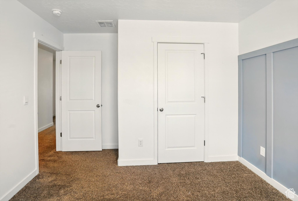 Unfurnished bedroom with carpet and a closet