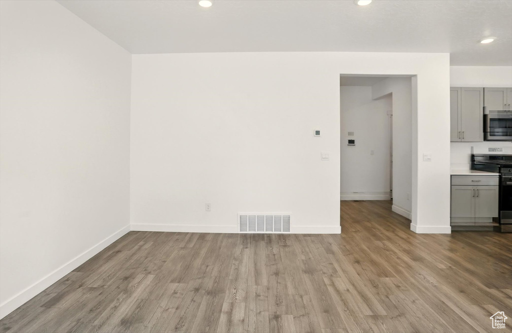 Unfurnished living room with wood finished floors and recessed lighting