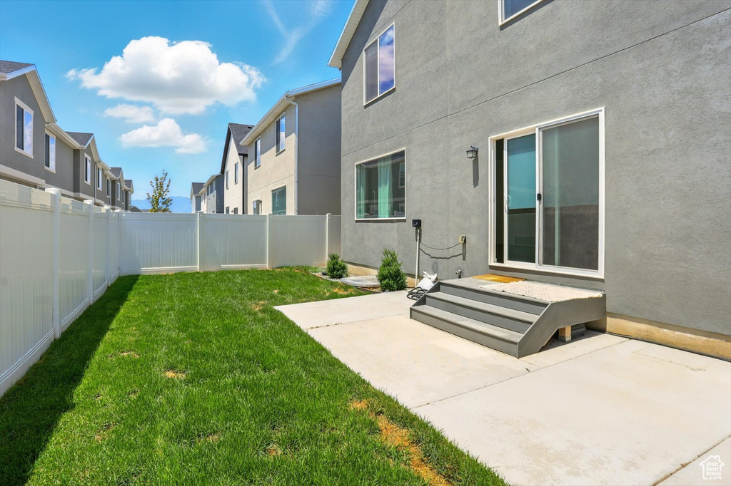 Fenced backyard featuring a patio and a residential view