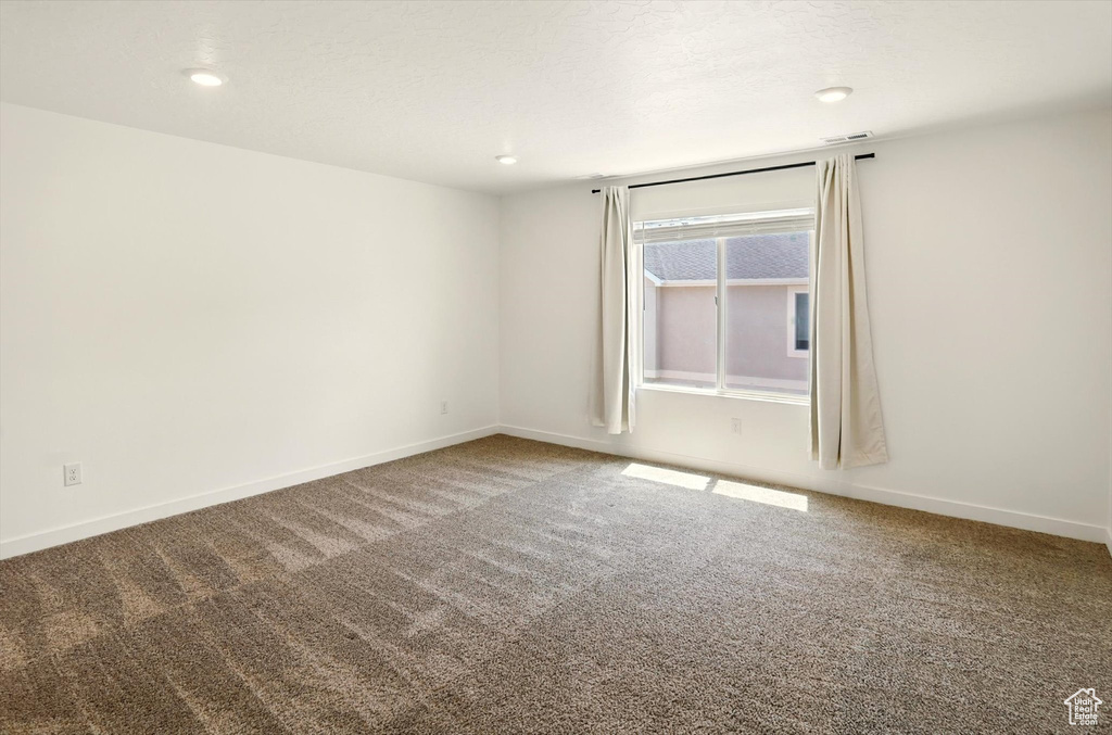 Empty room with carpet and recessed lighting