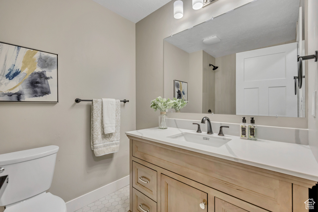 Bathroom with vanity, tile patterned flooring, and a shower