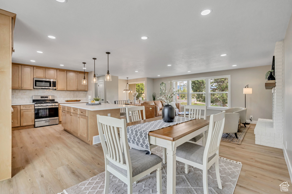 Dining room featuring healthy amount of natural light, light wood-type flooring, and recessed lighting