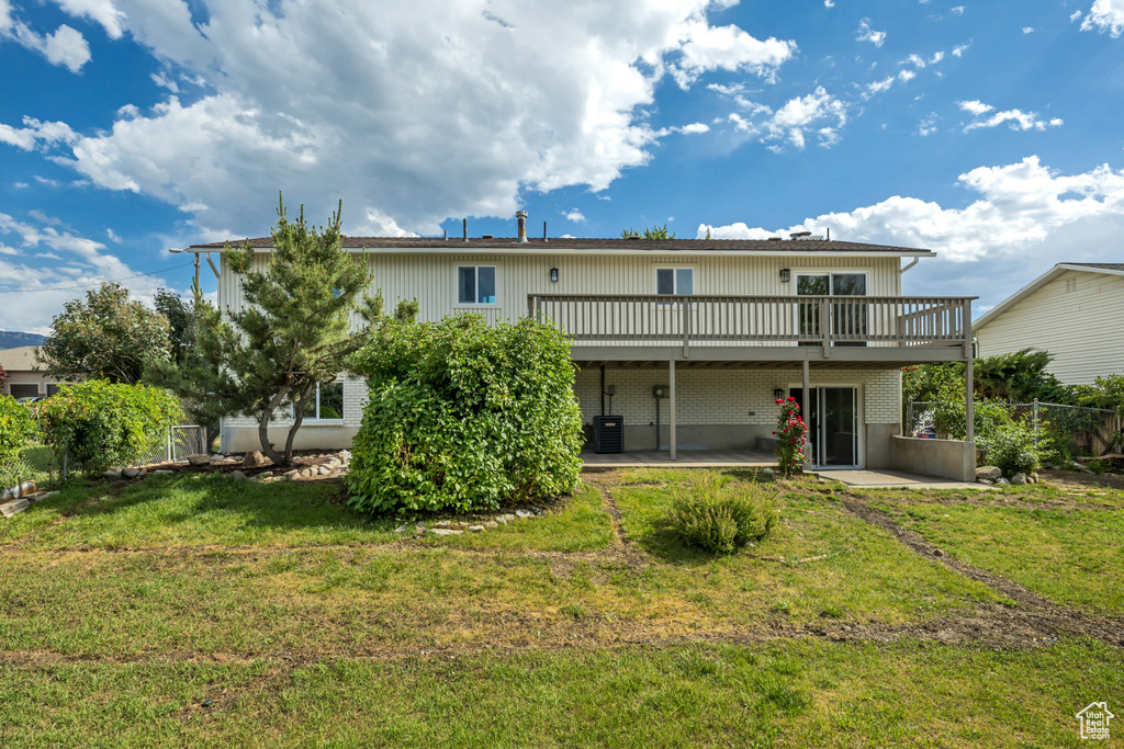 Rear view of house featuring a deck and a patio area