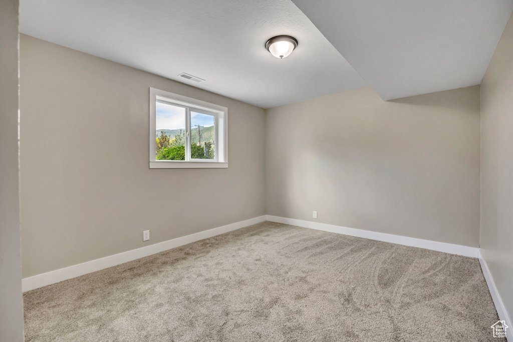 Carpeted spare room with baseboards