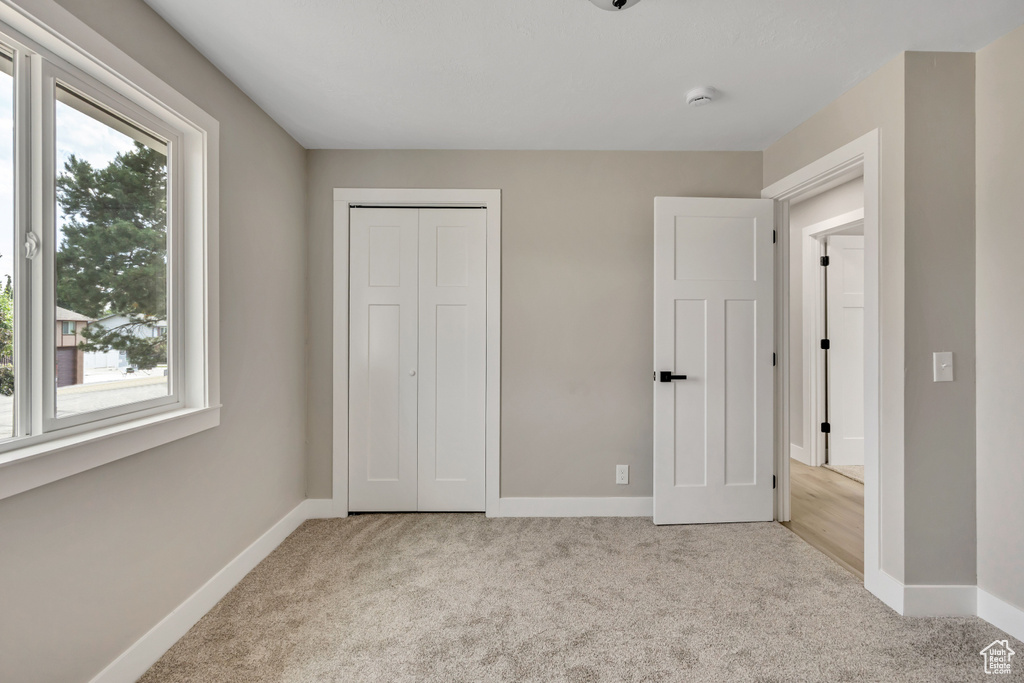 Unfurnished bedroom with carpet and a closet