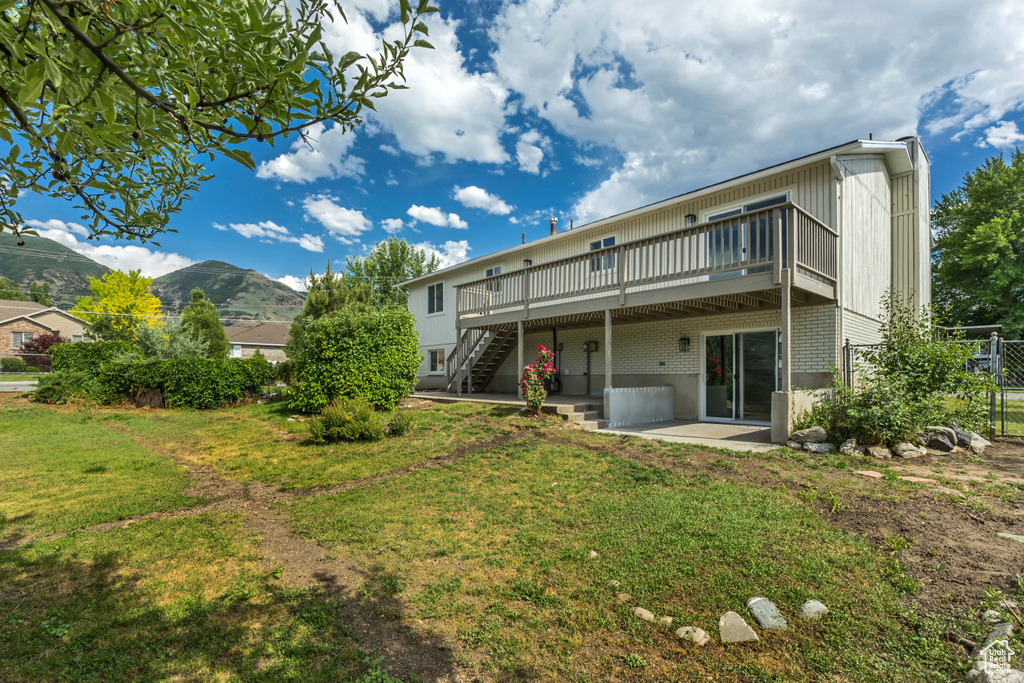 Back of house with a deck, a yard, stairway, and a patio area