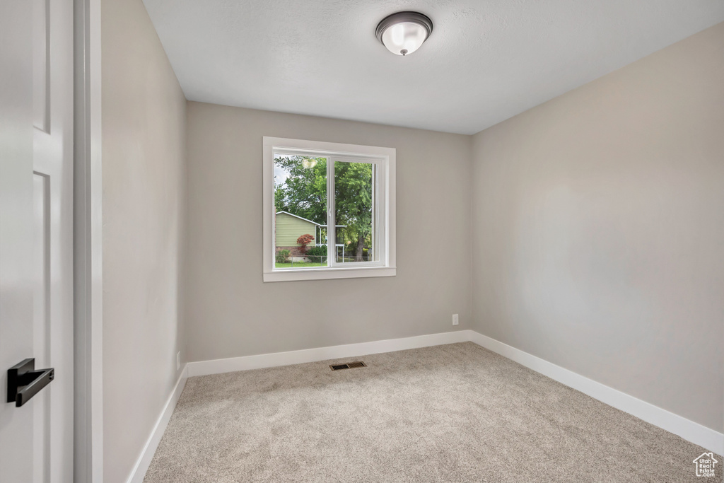 Carpeted spare room with baseboards