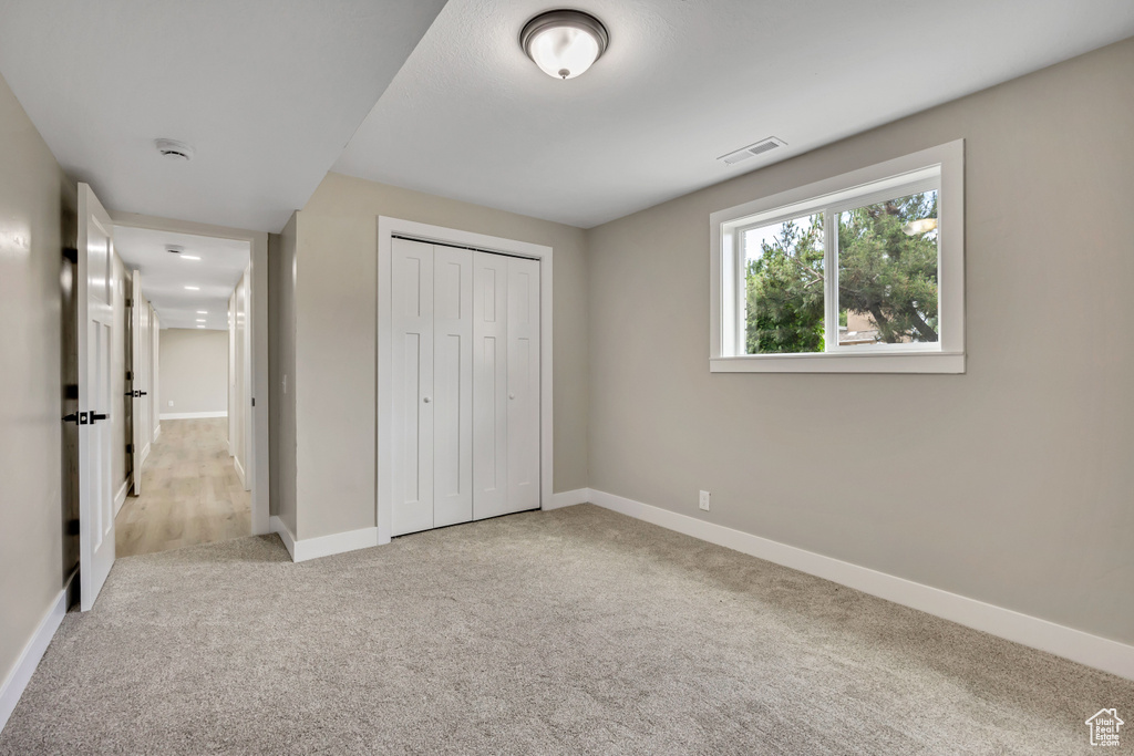 Unfurnished bedroom with carpet and a closet