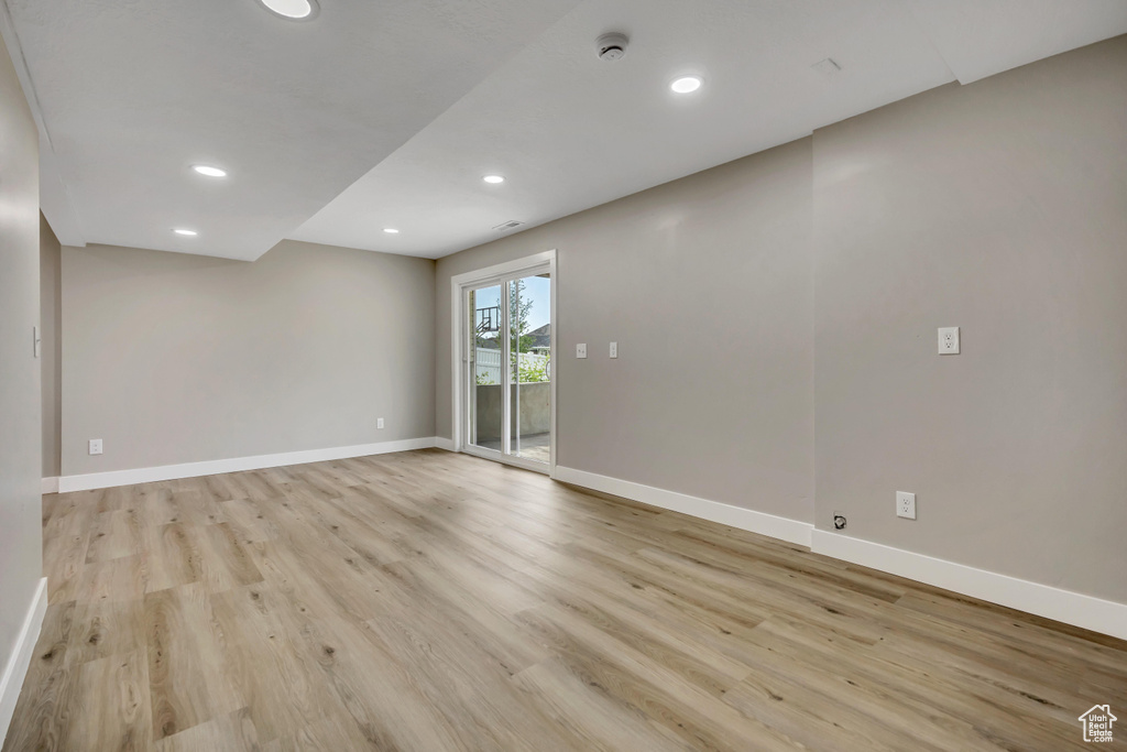 Unfurnished room with a smoke detector, light wood-style floors, and recessed lighting