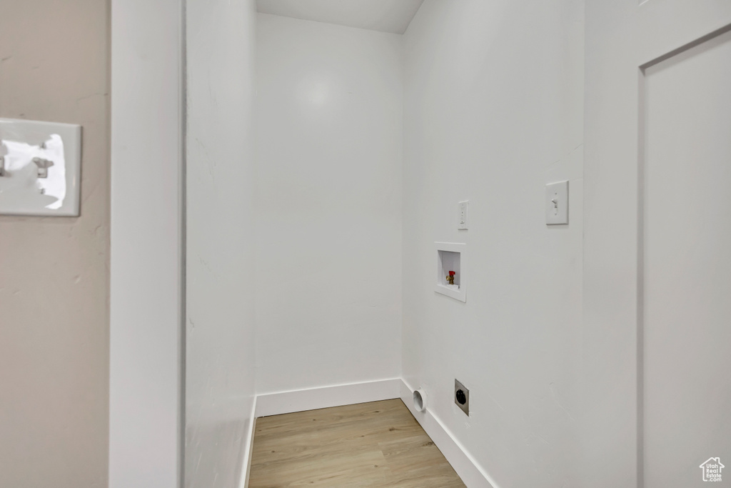 Laundry room with electric dryer hookup, washer hookup, and light wood finished floors