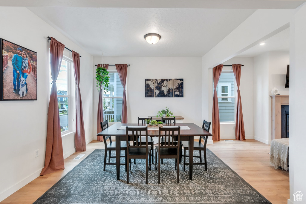 Dining space with light wood-style flooring, recessed lighting, and a glass covered fireplace