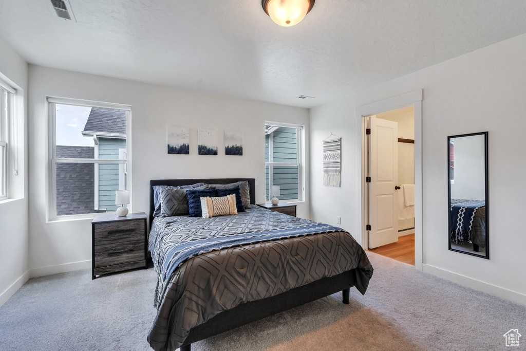 Carpeted bedroom with baseboards and connected bathroom
