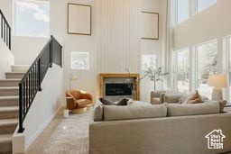 Living area featuring stairway, a high ceiling, and a fireplace