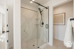 Bathroom featuring a marble finish shower and baseboards