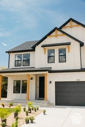 Modern farmhouse featuring an attached garage, a porch, and concrete driveway