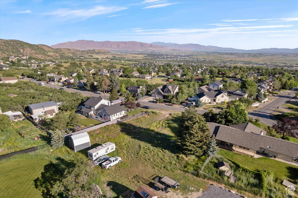 Aerial overview of property's location with a mountainous background and nearby suburban area
