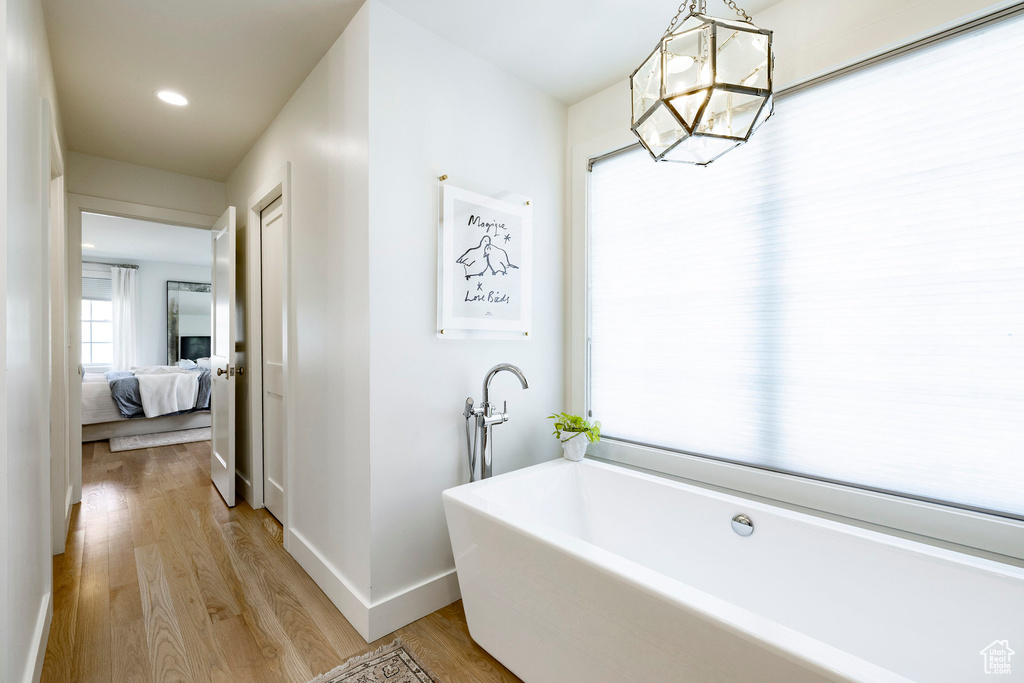 Full bathroom with a freestanding bath, wood finished floors, ensuite bathroom, and recessed lighting