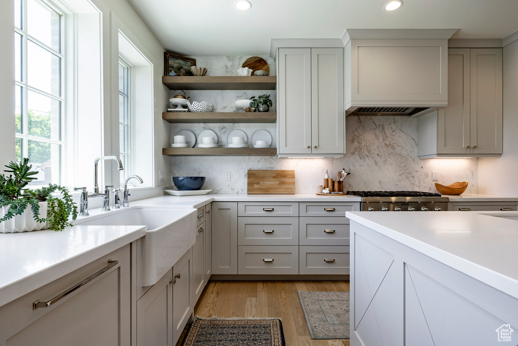 Kitchen featuring stainless steel gas stovetop, light countertops, recessed lighting, open shelves, and tasteful backsplash