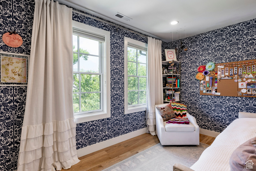 Living area featuring wallpapered walls, wood finished floors, and recessed lighting