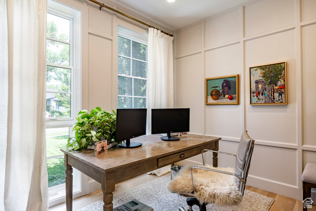 Home office featuring a decorative wall and light wood finished floors