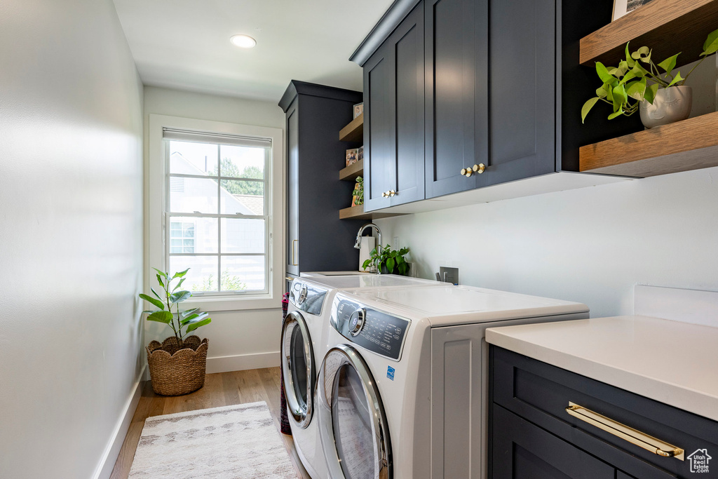 Laundry room with cabinet space, separate washer and dryer, light wood-type flooring, and recessed lighting