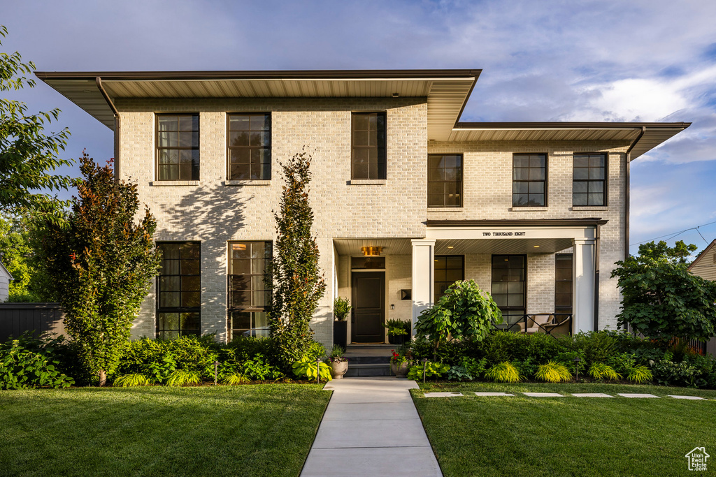 View of front of house featuring brick siding and a front yard