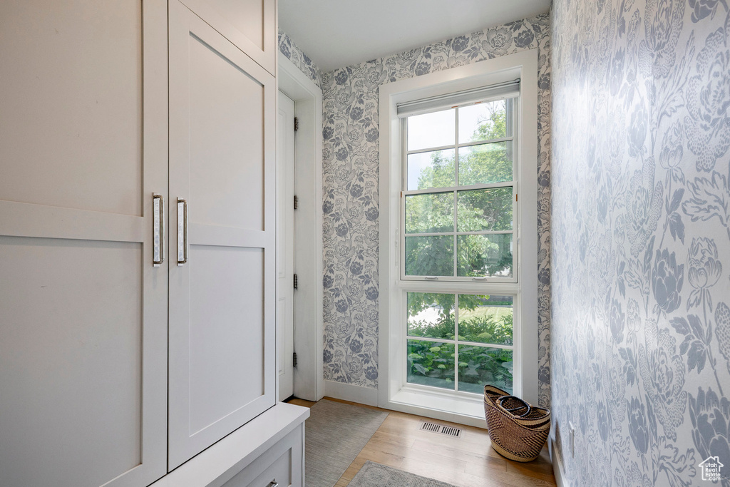 Bathroom with wallpapered walls and wood finished floors