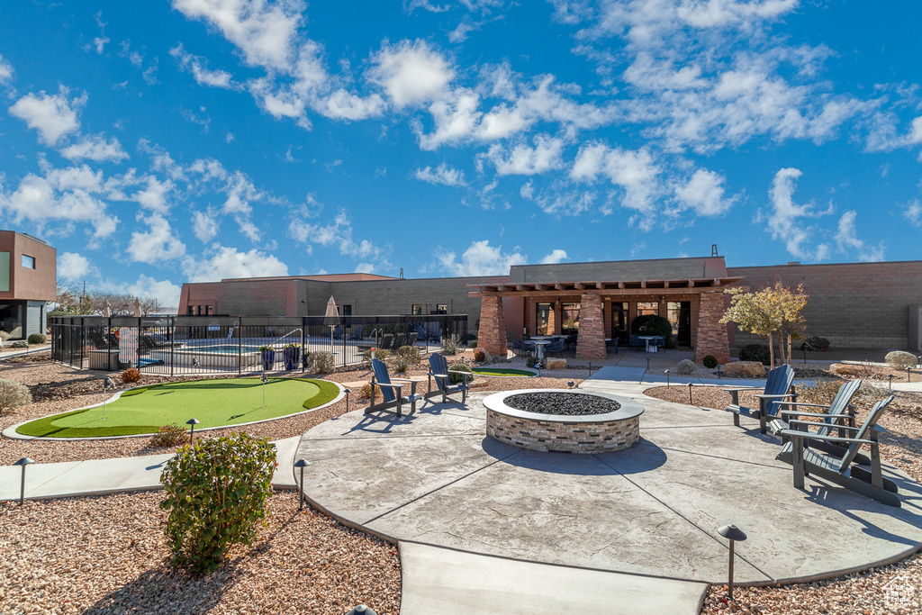 View of patio featuring a putting green and an outdoor fire pit
