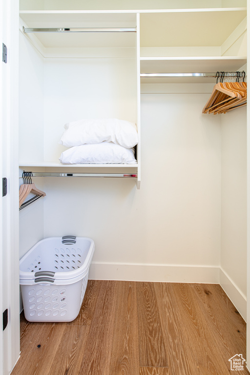 Walk in closet with wood finished floors