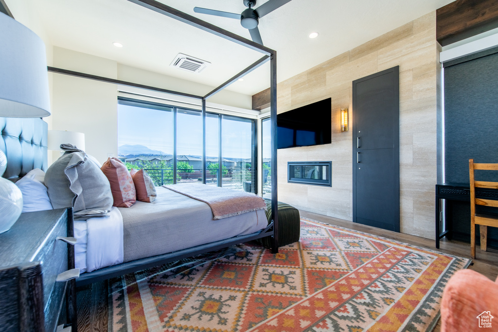 Bedroom featuring a large fireplace, recessed lighting, and floor to ceiling windows