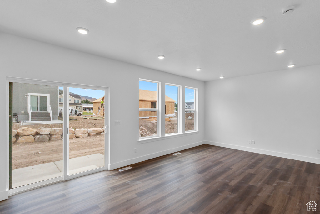 Unfurnished room with dark wood finished floors, recessed lighting, and a smoke detector