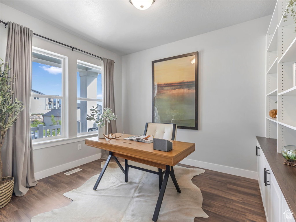 Office space featuring dark wood-type flooring and baseboards