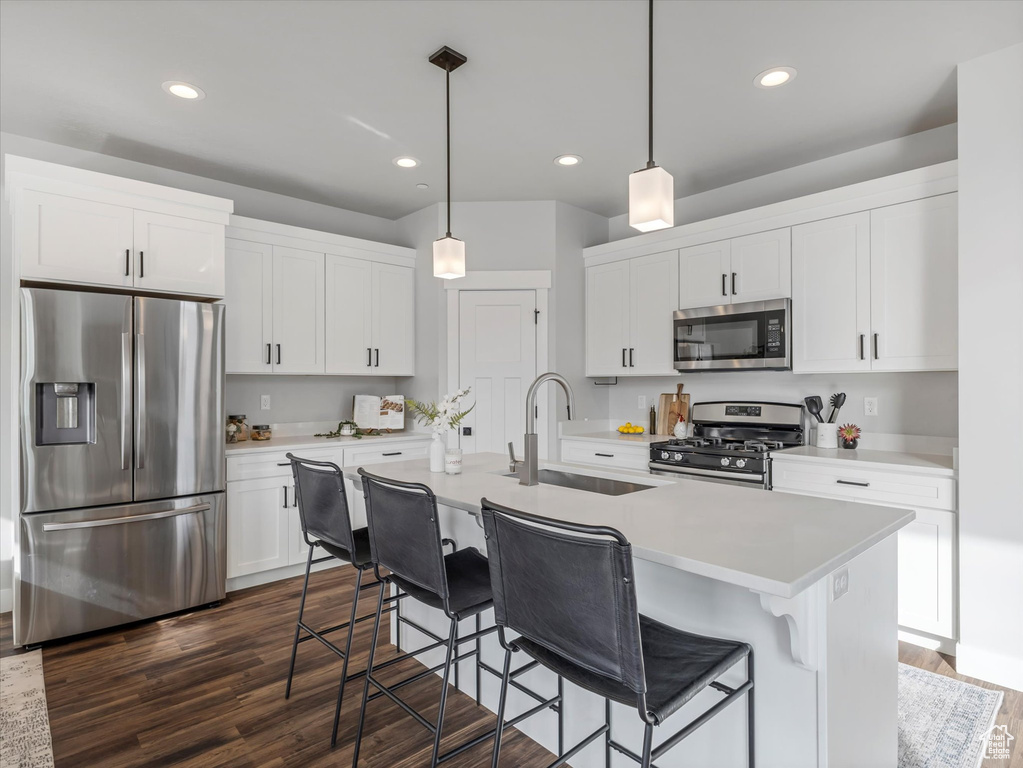 Kitchen featuring stainless steel appliances, recessed lighting, dark wood-style flooring, white cabinetry, and light countertops