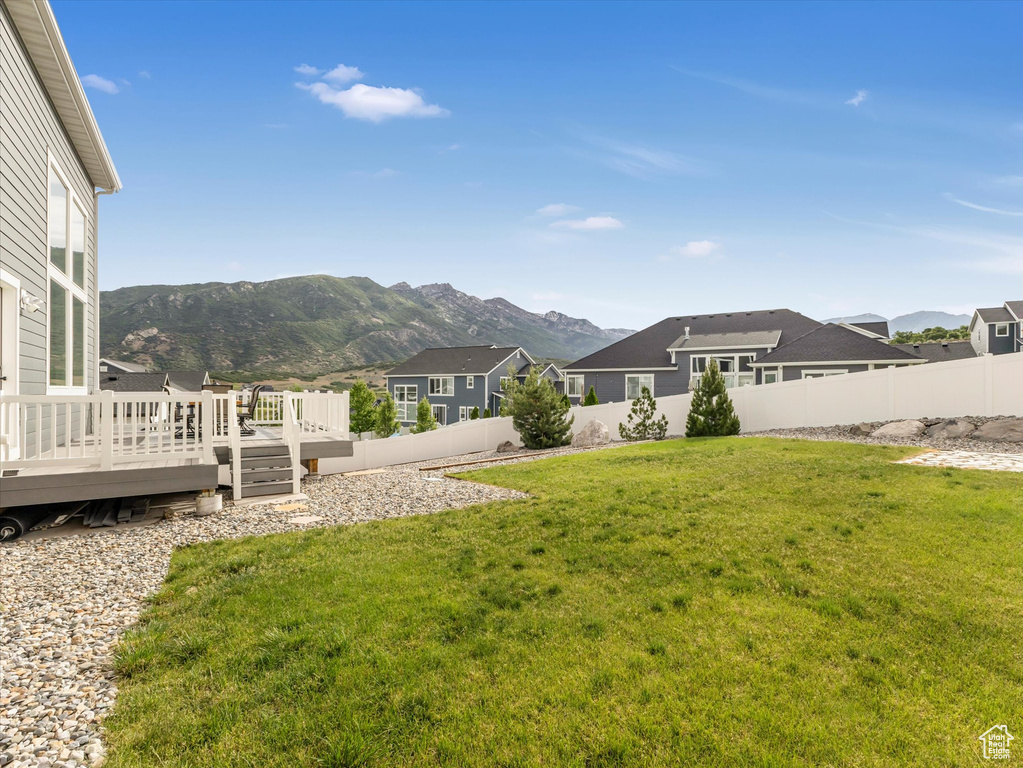Fenced backyard featuring a deck with mountain view and a residential view