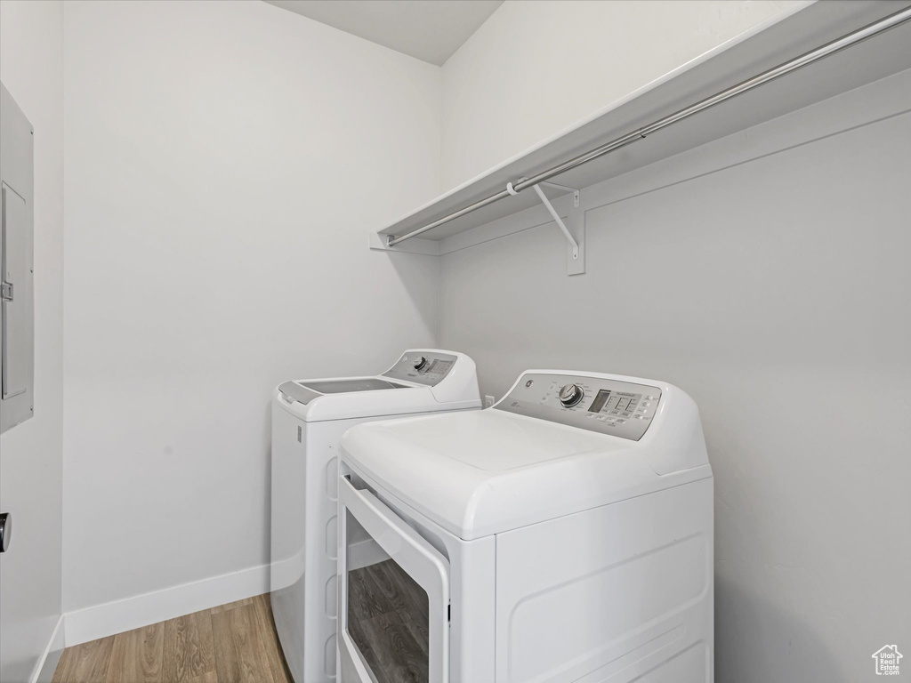 Laundry room featuring washer and dryer and light wood-type flooring
