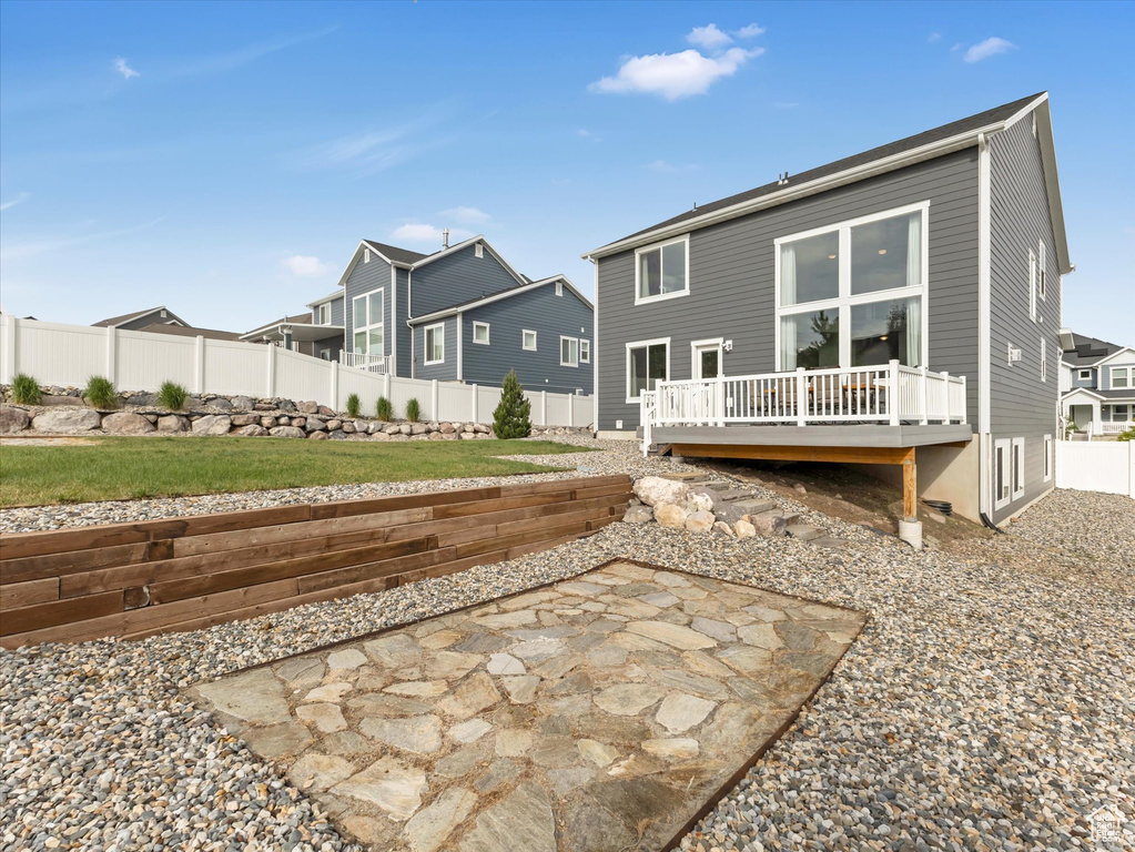 Rear view of property featuring a wooden deck, a fenced backyard, a residential view, and a patio