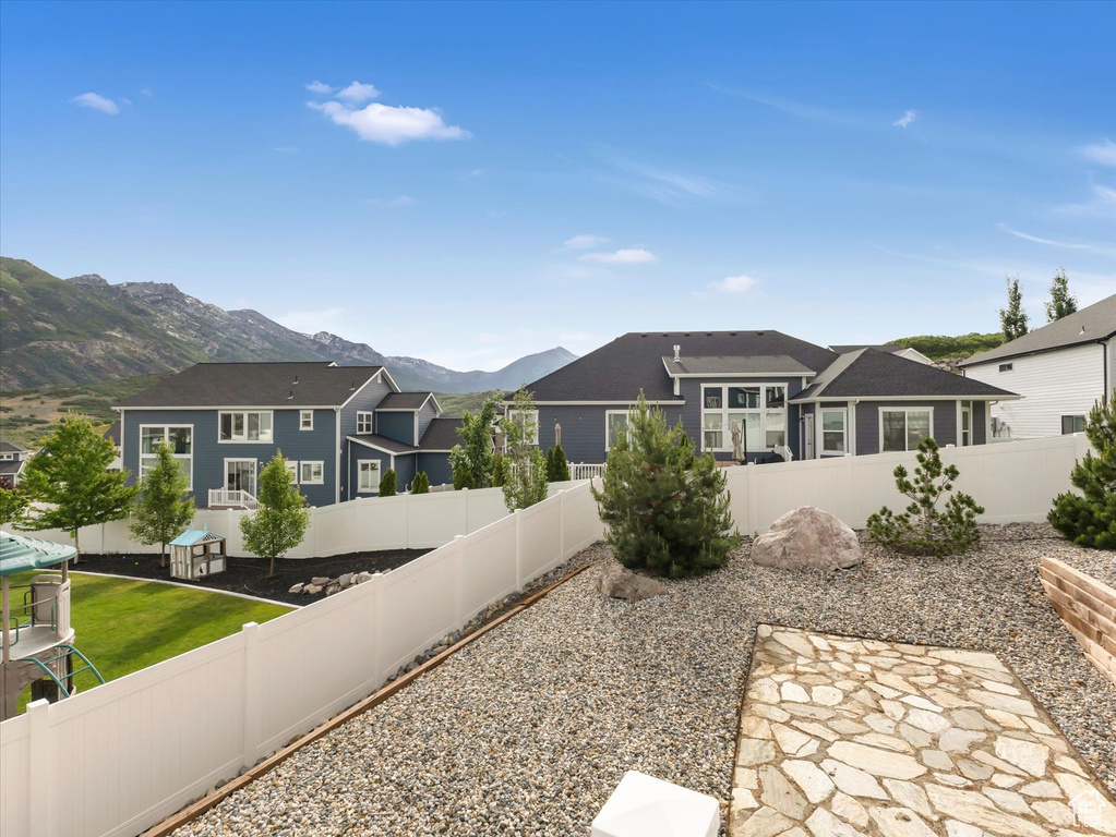 Fenced backyard featuring a mountain view, a residential view, and a patio