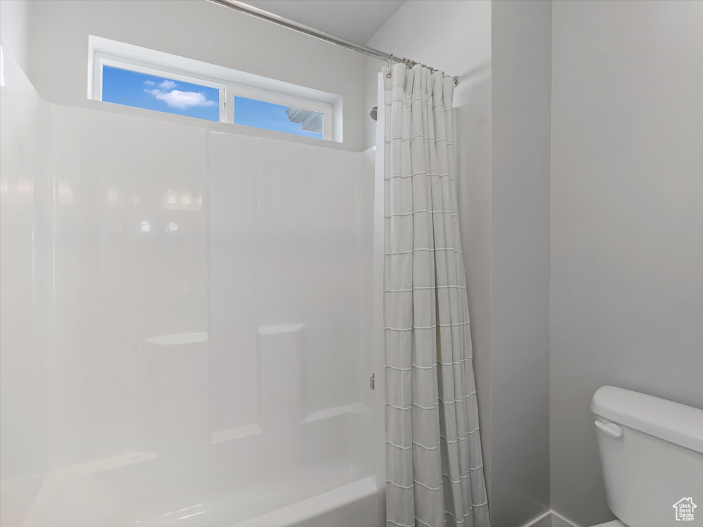Full bath with toilet and shower / tub combo with curtain