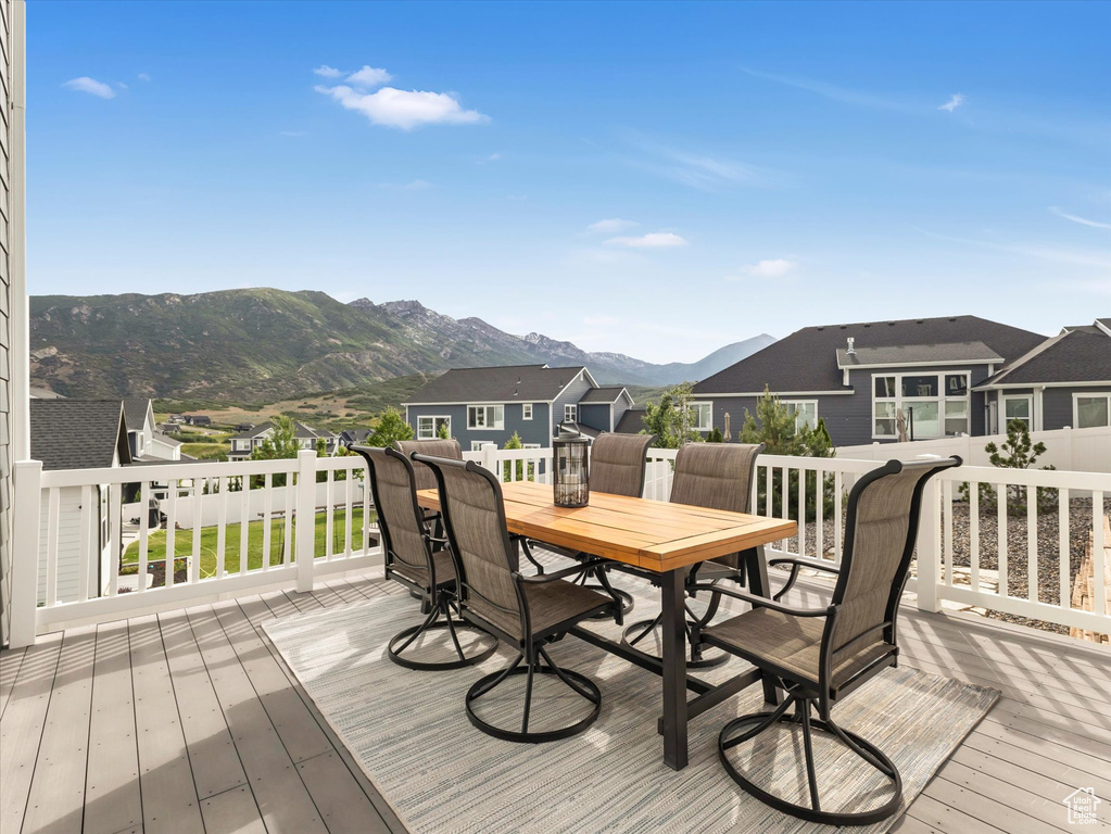 Deck featuring a mountain view, outdoor dining area, and a residential view