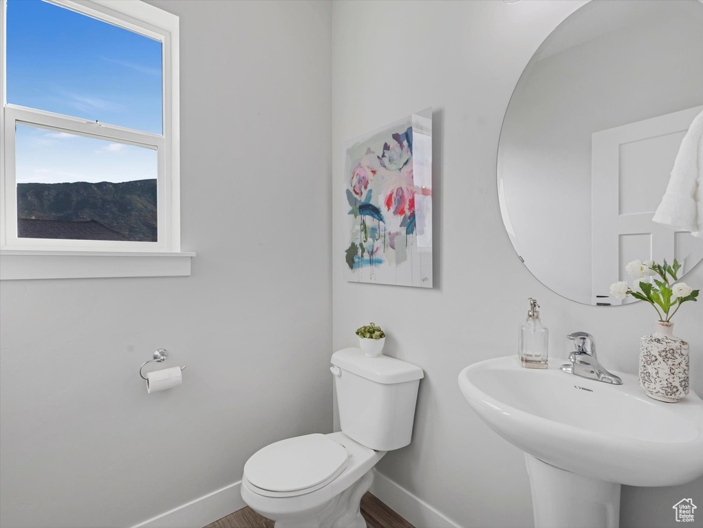 Half bathroom with baseboards and wood finished floors