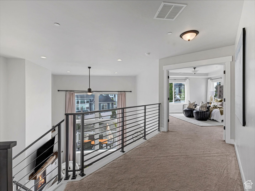 Hallway featuring an upstairs landing, carpet, and recessed lighting