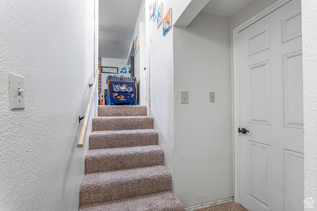 Stairs featuring a textured wall