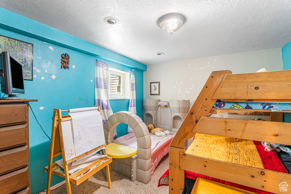 Bedroom featuring a textured ceiling and carpet floors