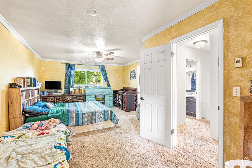 Bedroom featuring carpet, crown molding, a textured ceiling, wallpapered walls, and ceiling fan