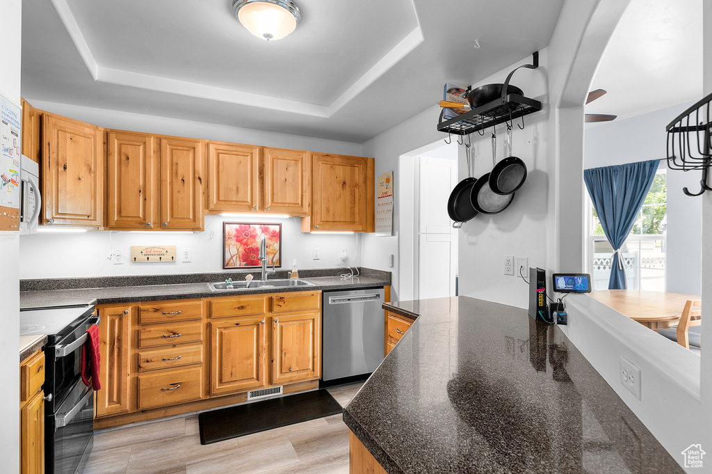 Kitchen featuring appliances with stainless steel finishes and a raised ceiling