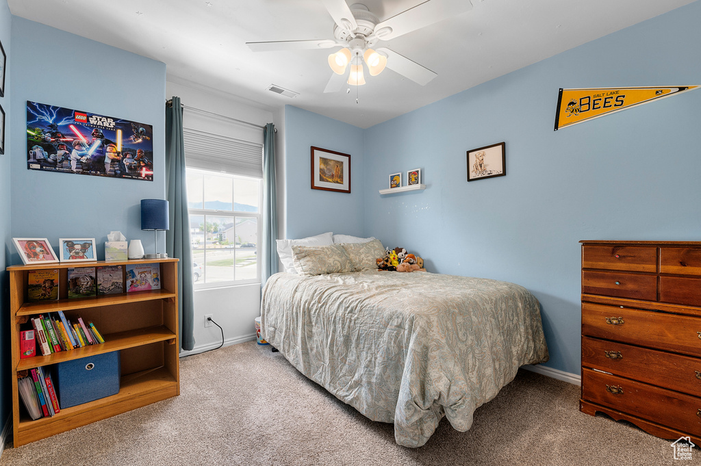 Carpeted bedroom featuring baseboards and ceiling fan