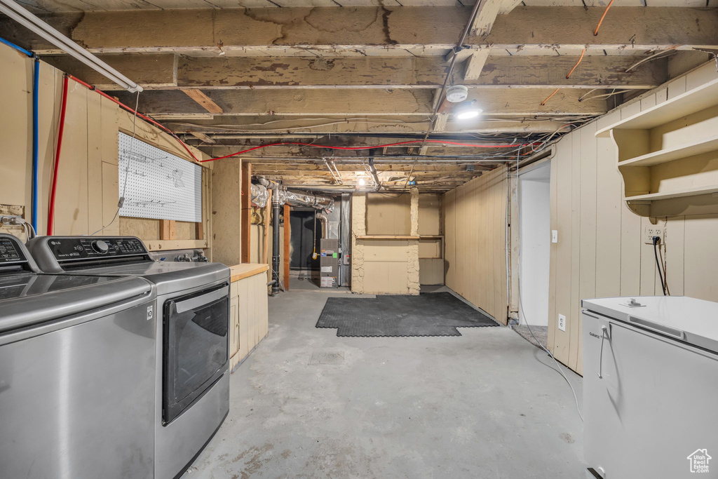 Unfinished basement featuring washer and dryer and refrigerator