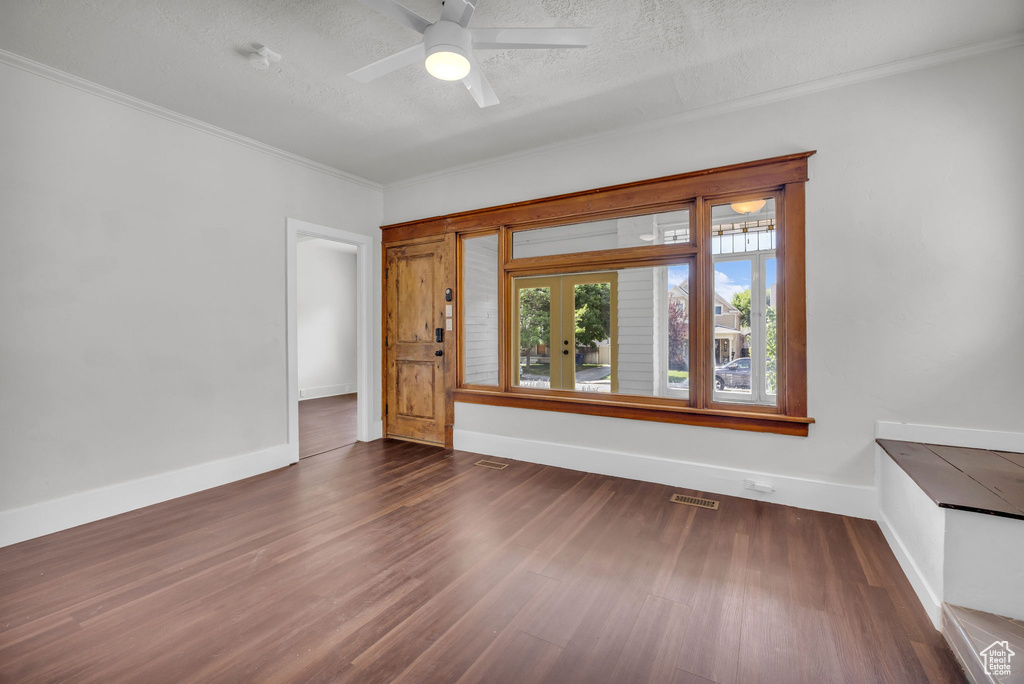Unfurnished room featuring wood finished floors, crown molding, a ceiling fan, and a textured ceiling